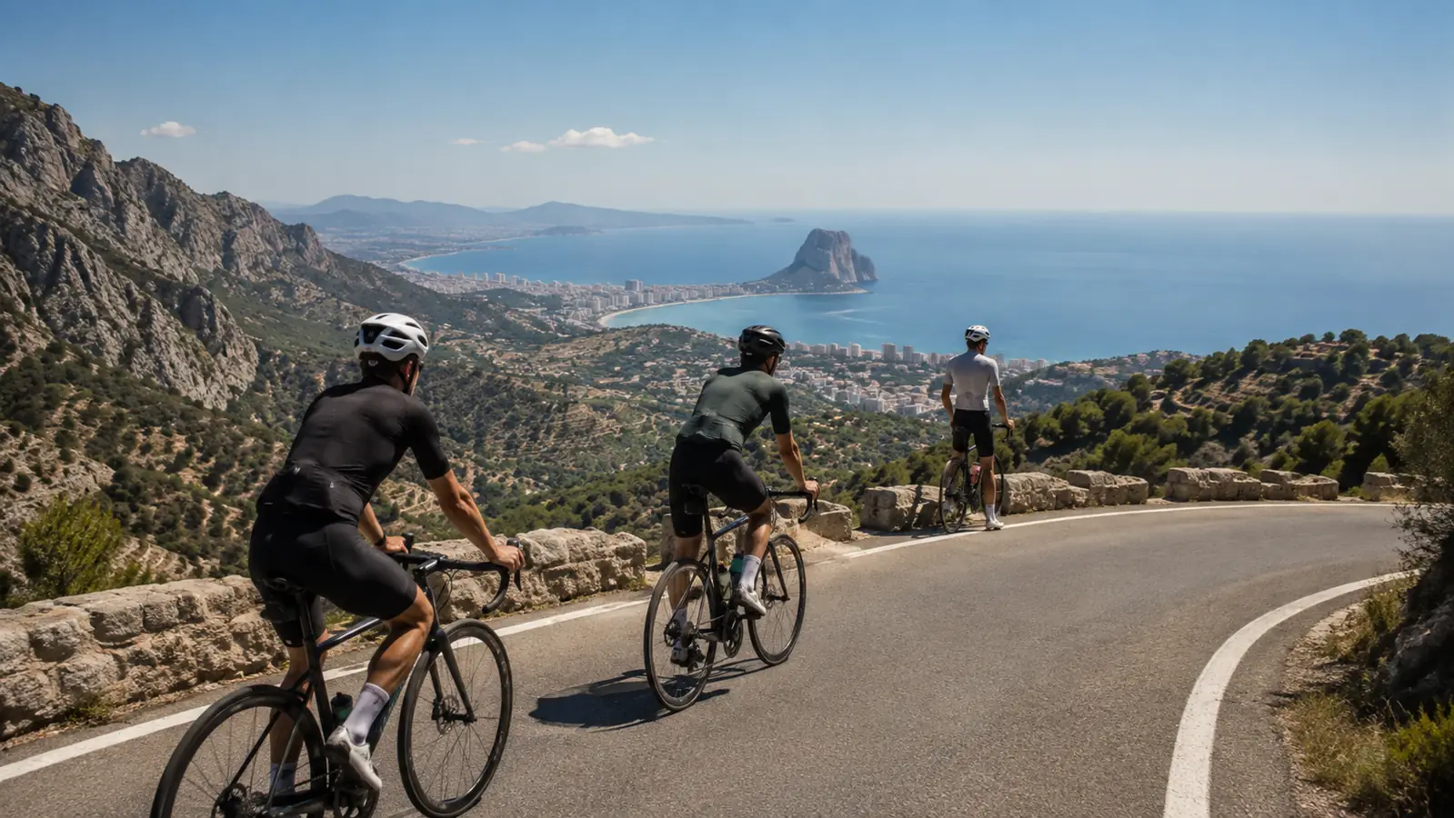 Kolarze szosowi na górskiej drodze Bèrnia z widokiem w kierunku Calpe i Peñón de Ifach