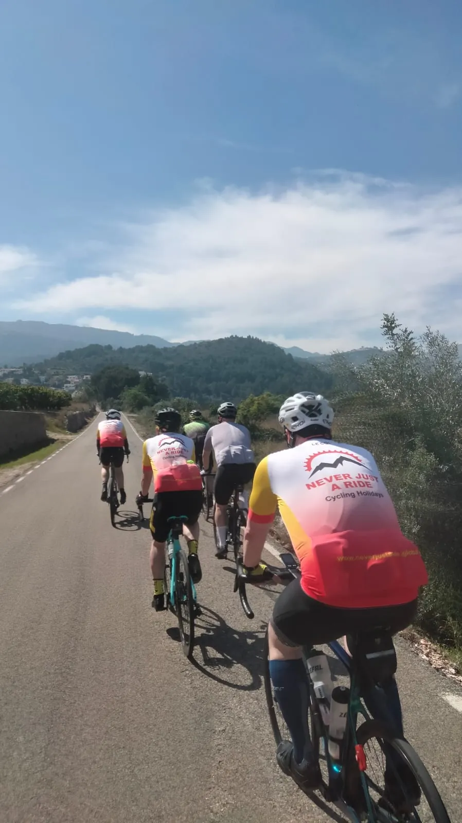 Grupa kolarzy szosowych jadąca przez krajobrazy Costa Blanca